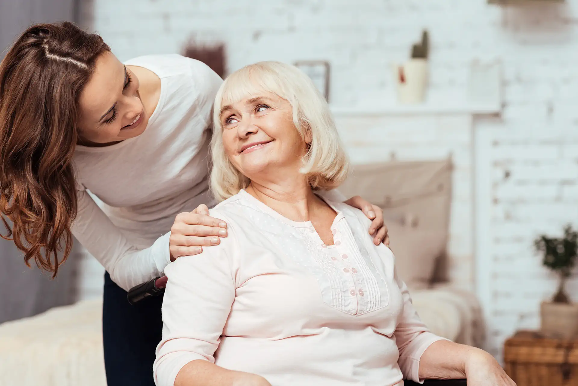 A caregiver with an elderly woman who is sitting in a wheelchair